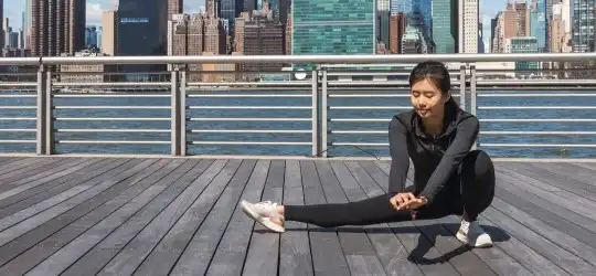 young woman stretching in city