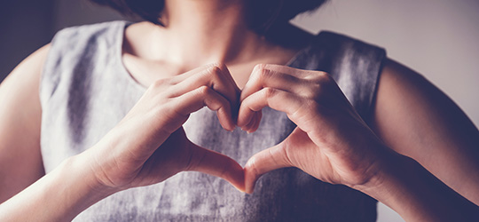 woman holding up heart