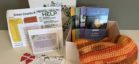 Care package with books, blanket, and resource cards.