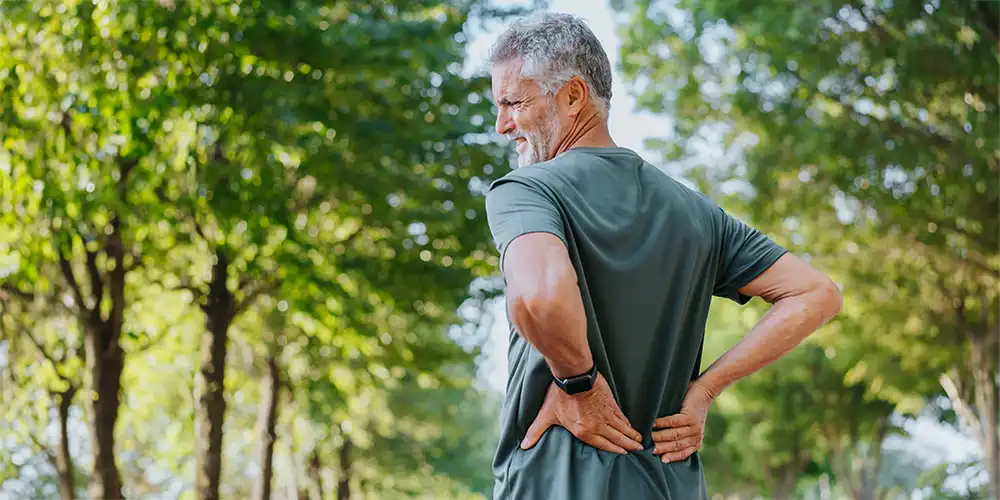 man holding lower back in pain