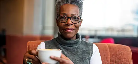 middle aged woman holding coffee cup