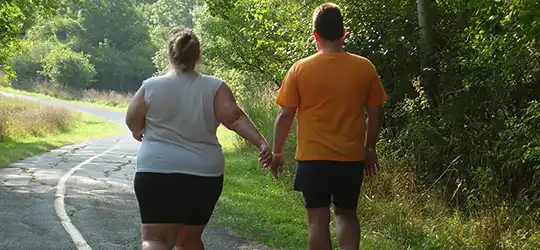 overweight couple walking on road