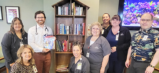 people smiling around little library 
