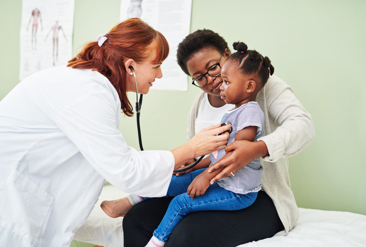 Doctor listening to little girl patient