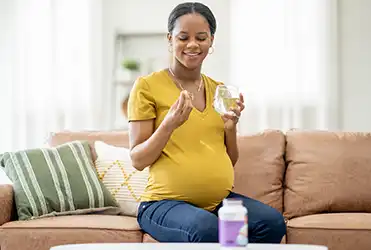 Pregnant woman looking at medications