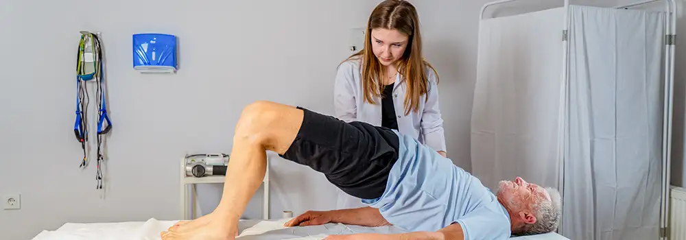 man doing bridge exercise with physical therapist