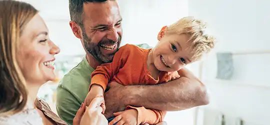 giggling little boy with parents 