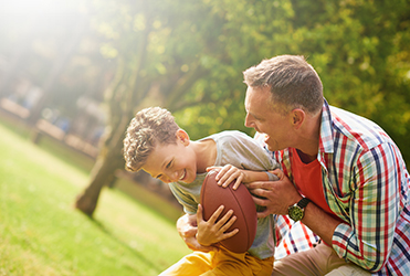 father and son playing football