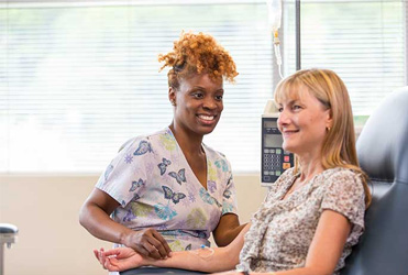 Women receiving infusion from nurse