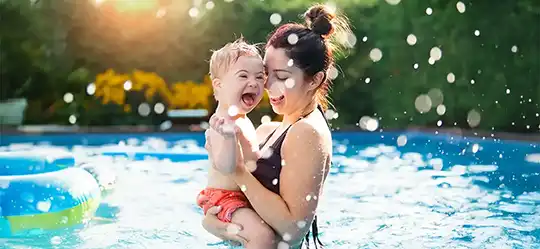 Young boy with Downs syndrome playing in pool
