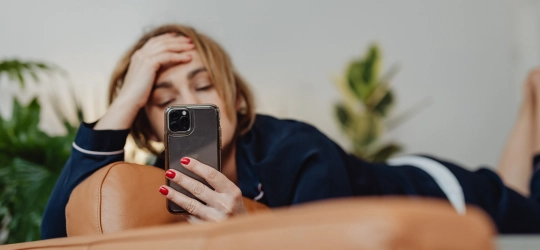 Woman using phone while lounging.