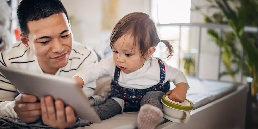 father showing baby tablet