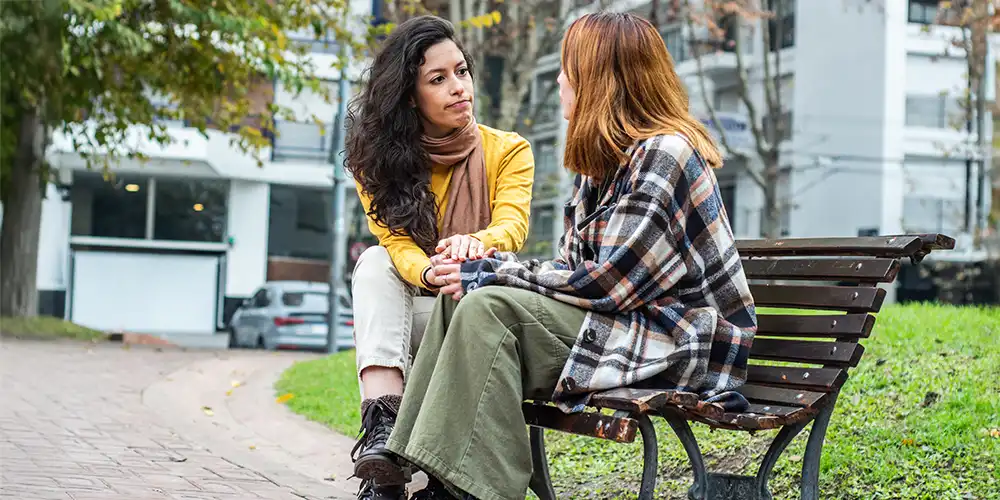 mentor and caregiver having a conversation on a park bench