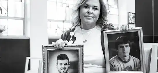 Jennifer Torbeck holding pictures of her sons