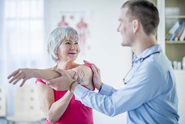senior woman receiving physical therapy on her shoulder