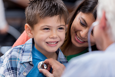 child having lungs listened to at checkup