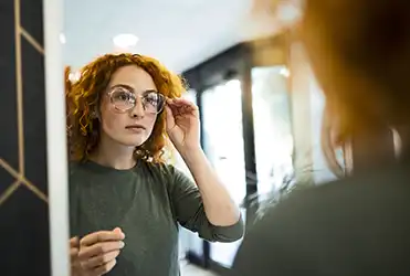 young woman trying on glasses 