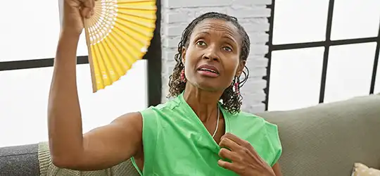 woman with perimenopause fanning herself
