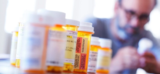 man looking at prescription medicine