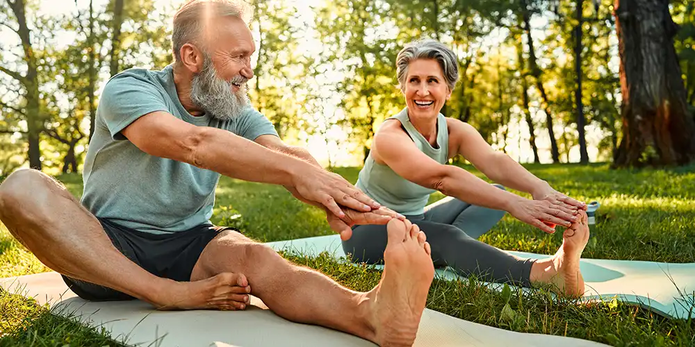 man and woman stretching on a yoga mat