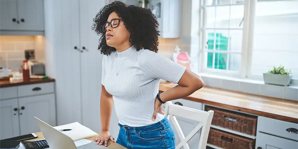 woman holding lower back in pain