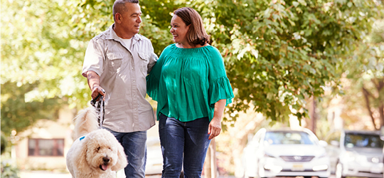 man and woman walking dog