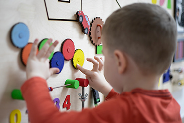 boy playing with gears on a board