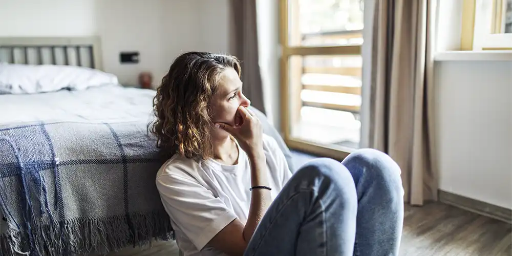 woman sitting on bedroom floor