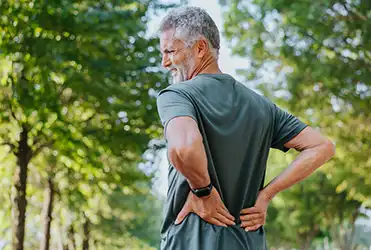 man holding lower back in pain