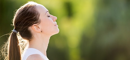 woman in nature with eyes closed