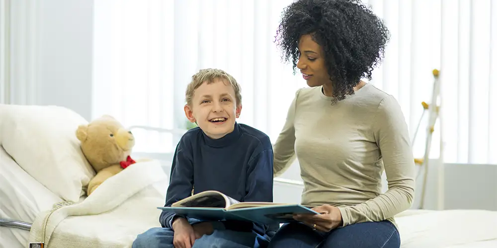 volunteer reading to child in hospital bed