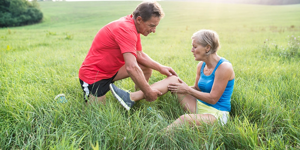 senior woman in field with knee pain