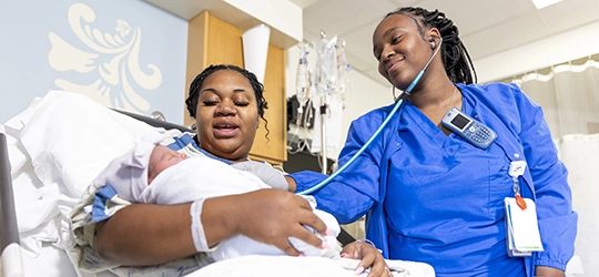 woman holding a baby with nurse