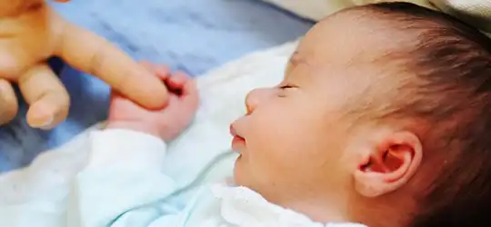 sleeping baby holding adult finger