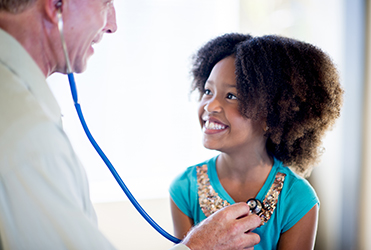 doctor listening to young girls heart