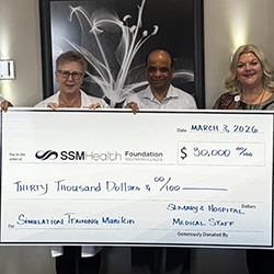 SSM Health St. Mary’s Medical Group team holding thirty thousand dollar check.