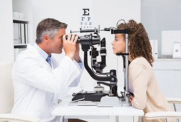 woman looking through eye exam machine