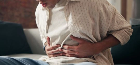 Person grabbing aching stomach.
