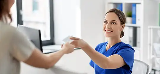 nurse handing patient their insurance card