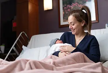woman holding baby in hospital bed