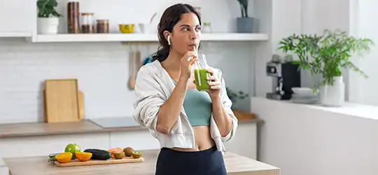 woman drinking a green smoothie after workout