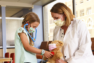 doctor listening to child with a stethescope
