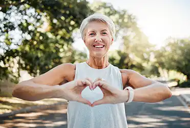 middle aged woman making heart hands