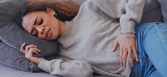 woman holding abdomen due to period pain