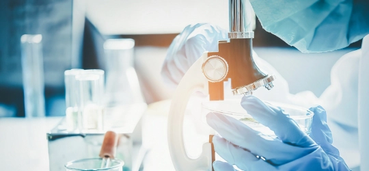 Physician using microscope.