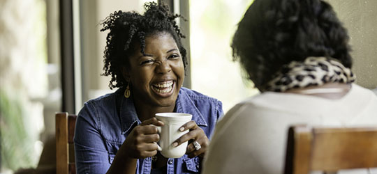 women drinking coffee and smiling