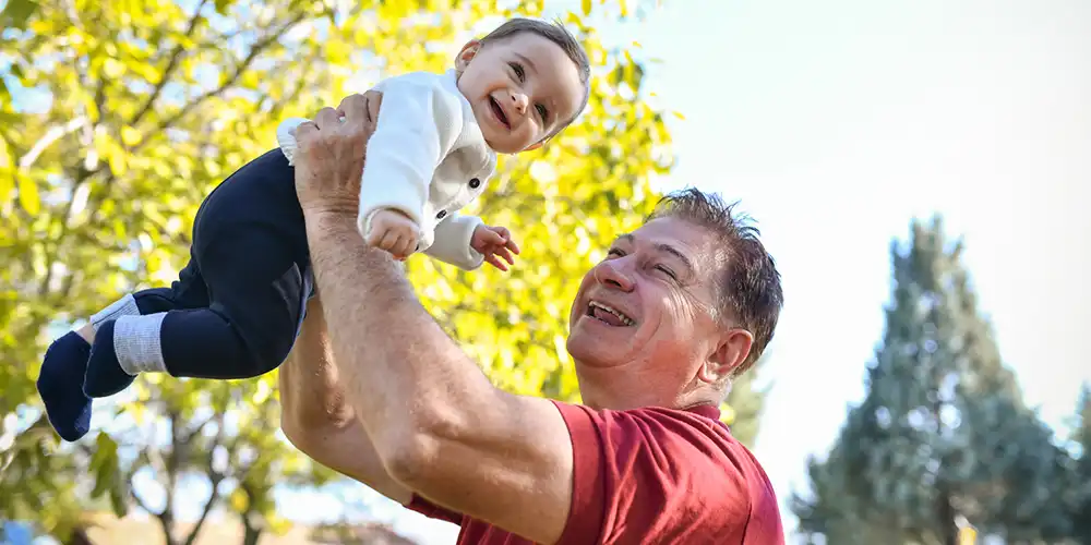 grand father lifting child over head
