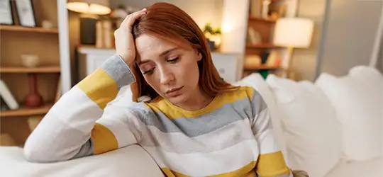 depressed woman sitting on couch