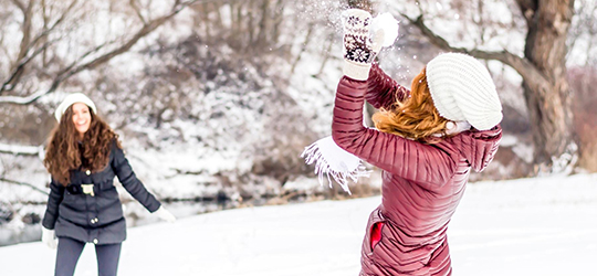 two women playing in the snow