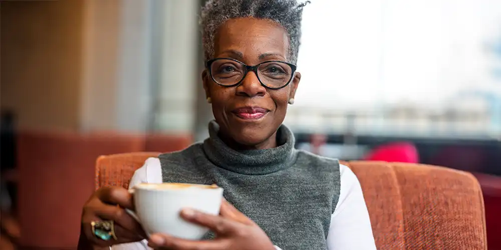 middle aged woman holding coffee cup